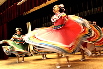 Female folklorico dancers performing on stage