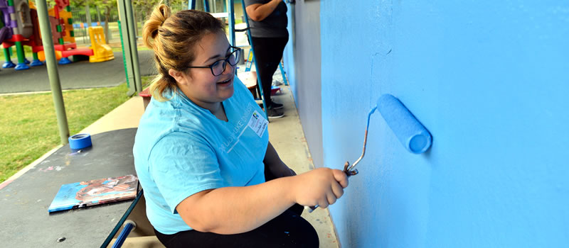 Female volunteer painting wall 