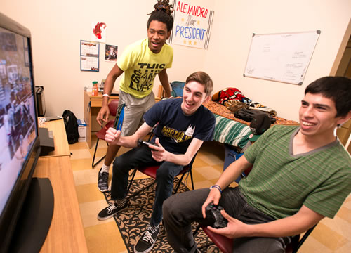 Male students playing video games in dorm room