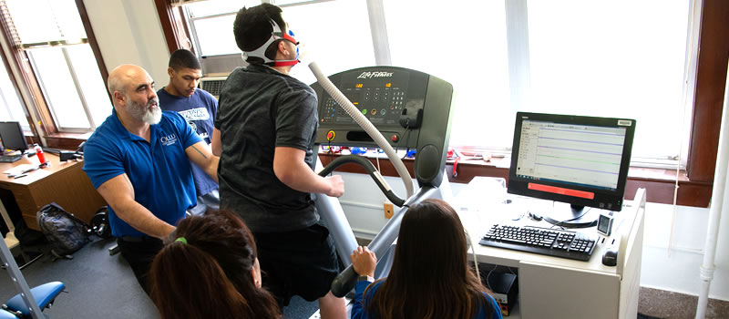 Professor works with students in kinesiology lab