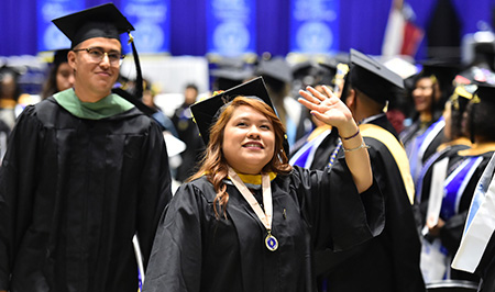 Graduate crossing the stage smiling