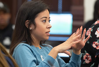 Female student wearing blue top talking 