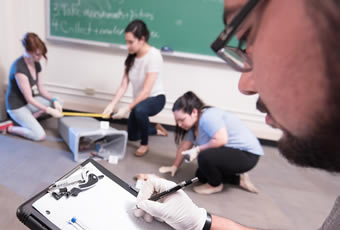 Group of students examining mock crime scene