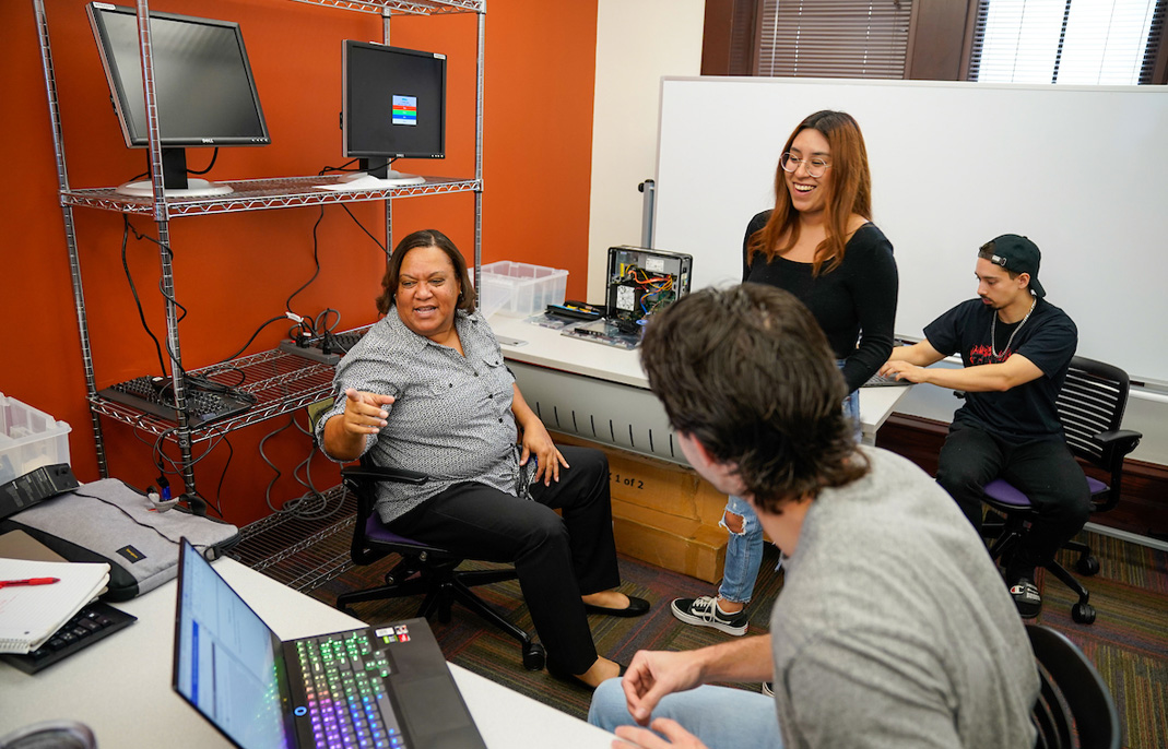 Cybersecurity prof talking with small group of students