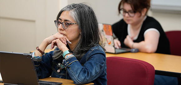 Female graduate student intently listening in class