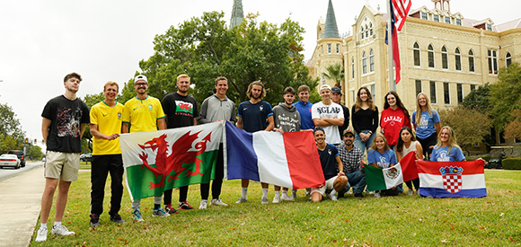 International students stand with different country flags outside