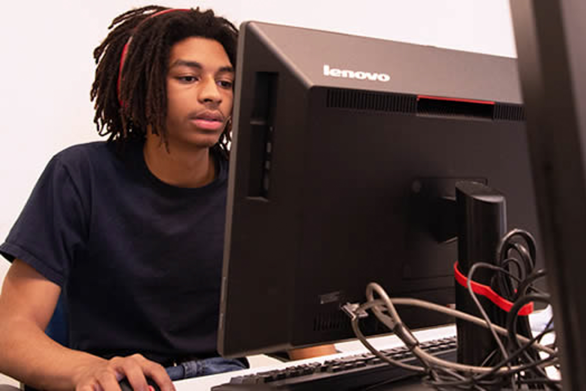 Student working on a computer in a cybersecurity program, representing AI and automation in cybersecurity education at OLLU.
