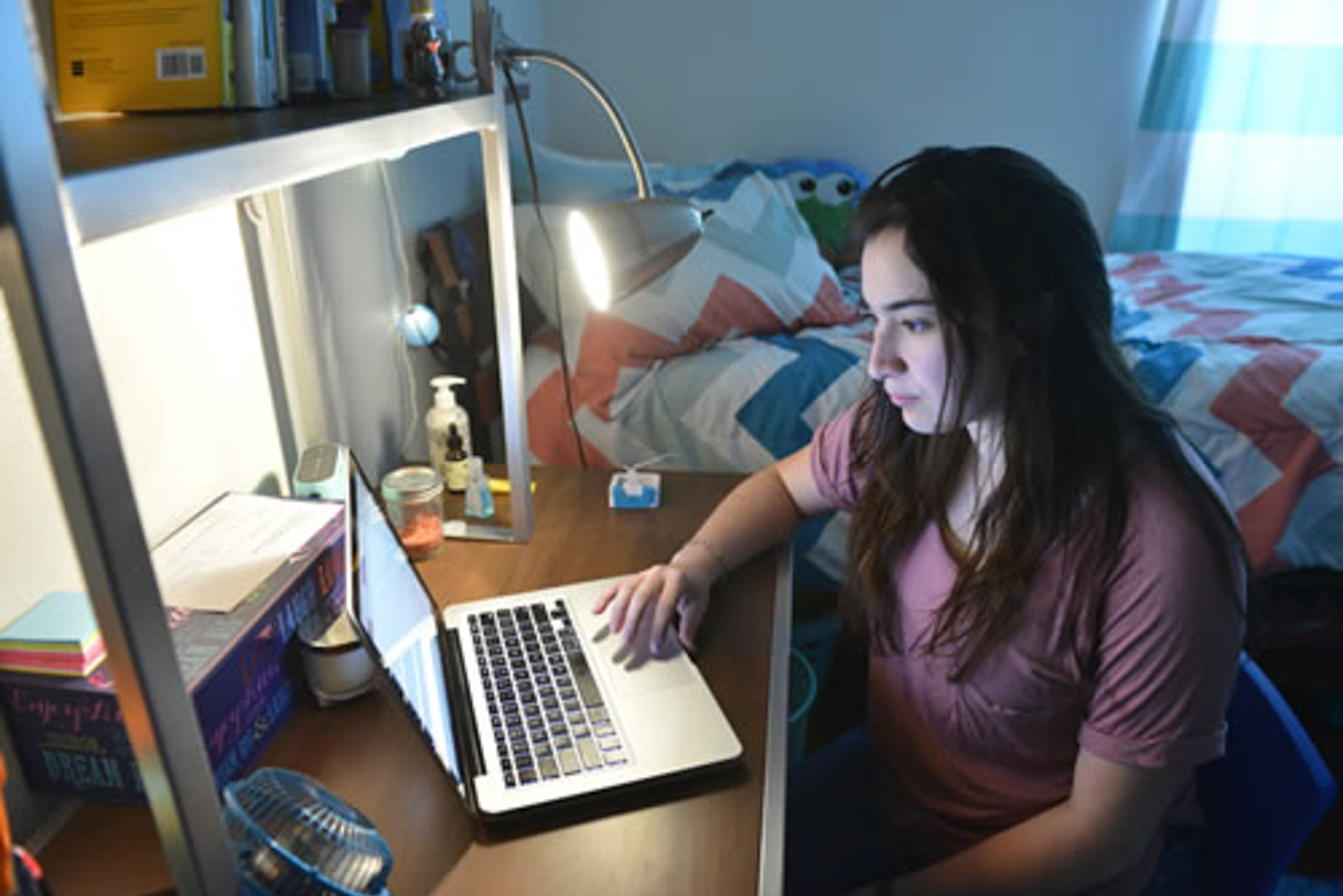 College student studying in a dorm room at OLLU, preparing for career success after graduation in San Antonio
