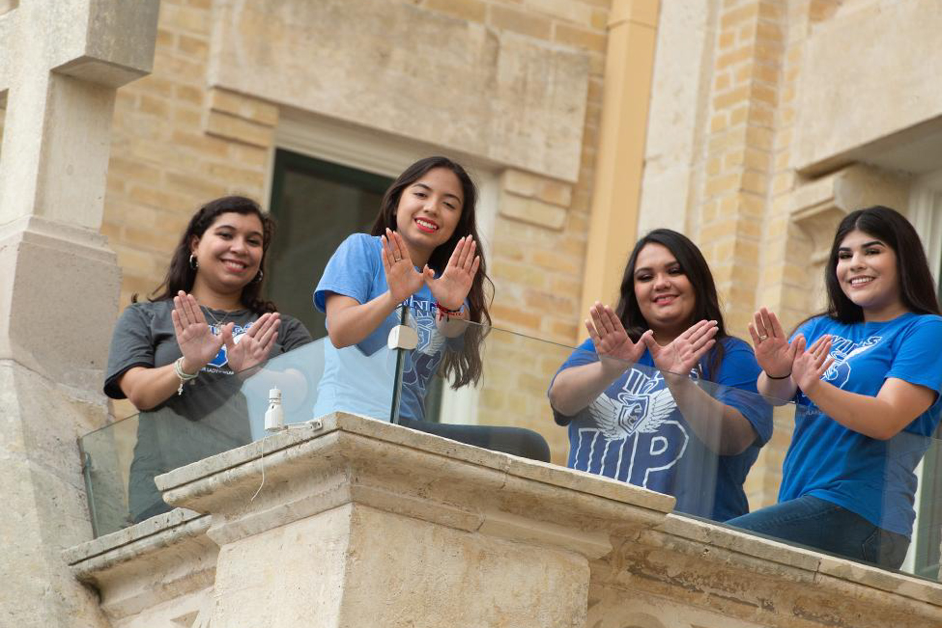 Students gathered outdoors on campus at OLLU, preparing for college life after acceptance in San Antonio.