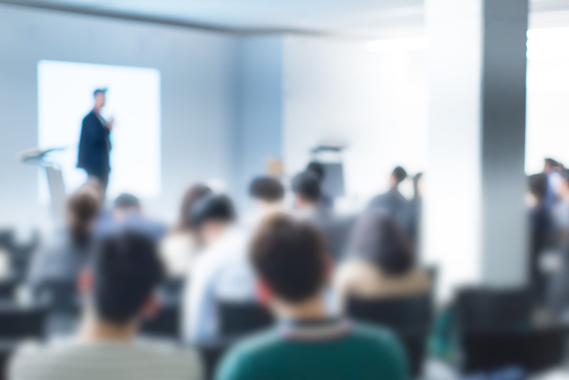 Blurred audience attending a conference lecture, symbolizing the foundational knowledge gained from the best undergraduate degree for an MBA program.