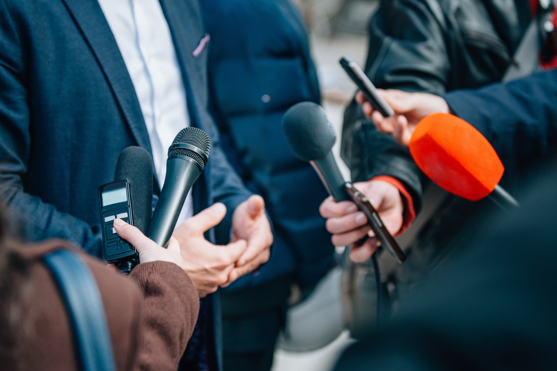 Live press conference media reporters, exemplifying careers achievable with a mass communication degree.