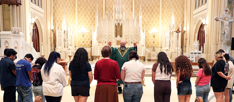 Father praying over congregation