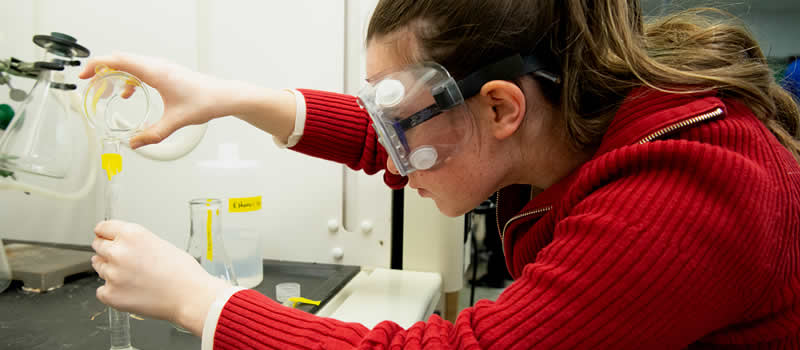 Female student measuring chemicals in chemistry lab