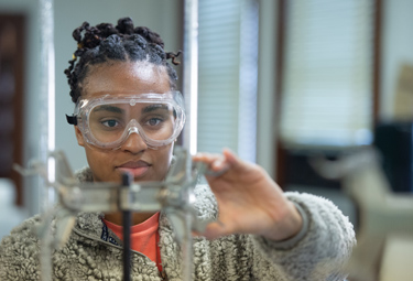 student adjusting instrument in chemistry lab