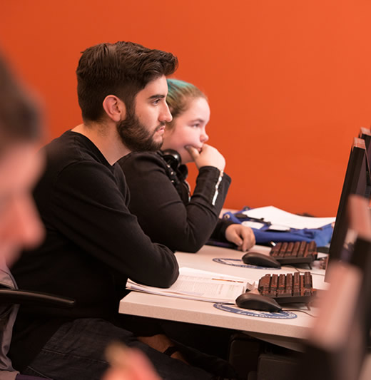 Two students sitting at computers in class