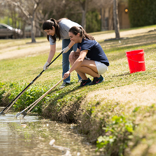 Students gathering lake water samples 