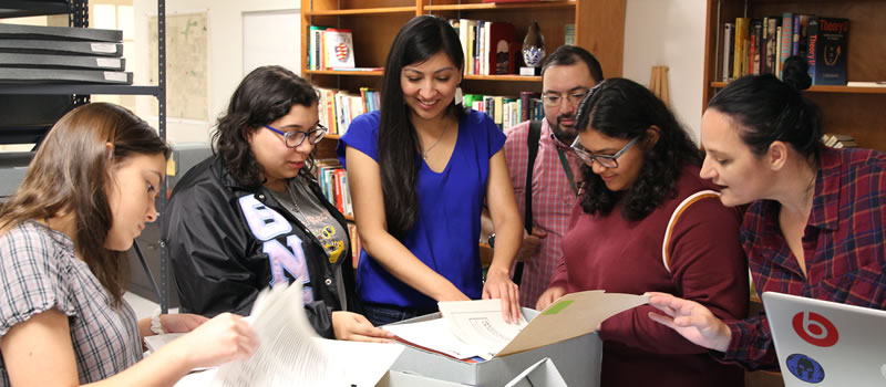 History professor works with group of students in university archives