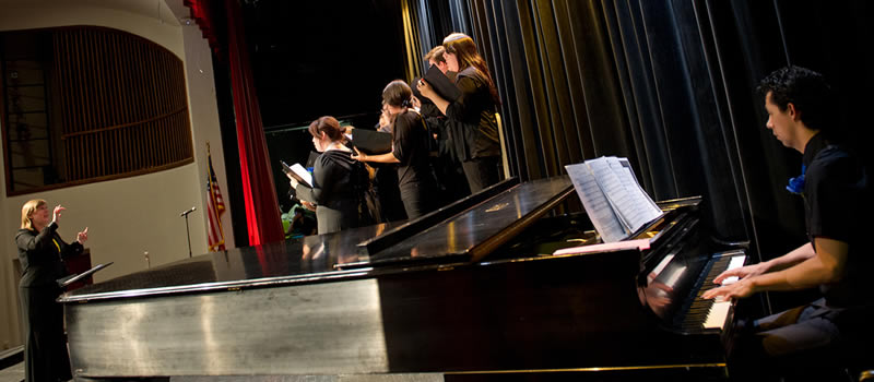 Music professor directing students on stage