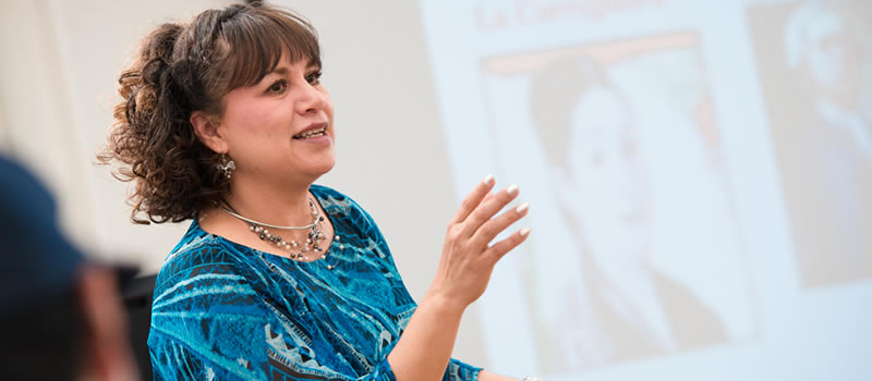 Spanish professor stands in front of classroom