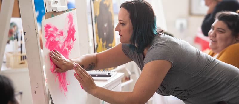 Female student paints picture with her hands
