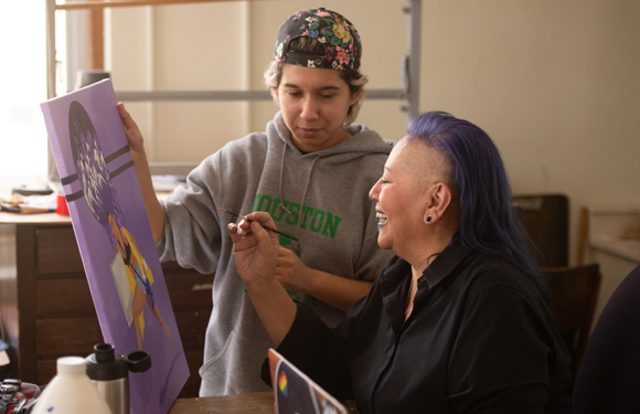 Professor working with student in art class