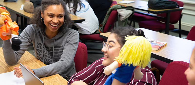 female students holding puppets