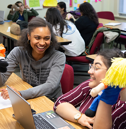 Students in class holding puppets