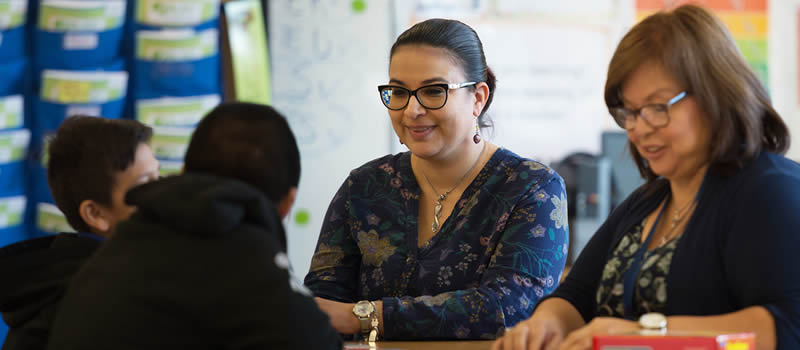 Female teachers work with students in classroom