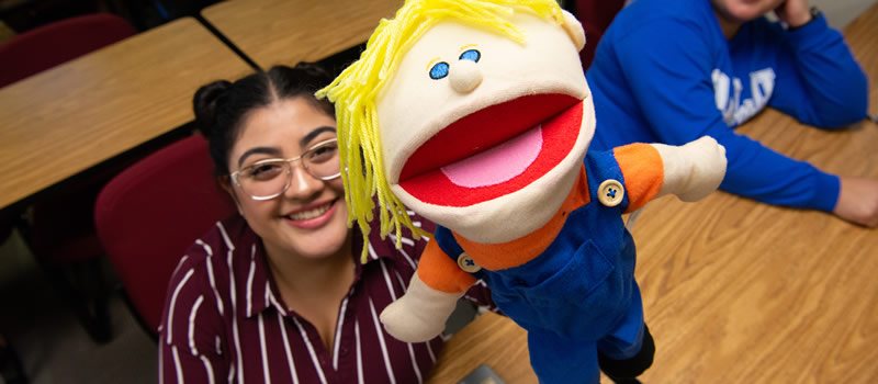 female student holding puppet
