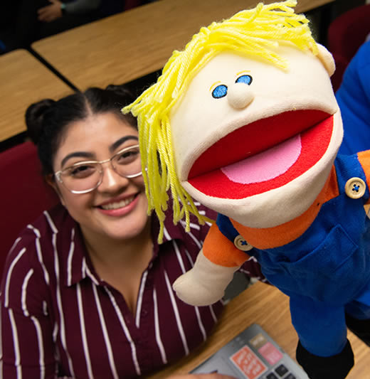 Female student holding puppet