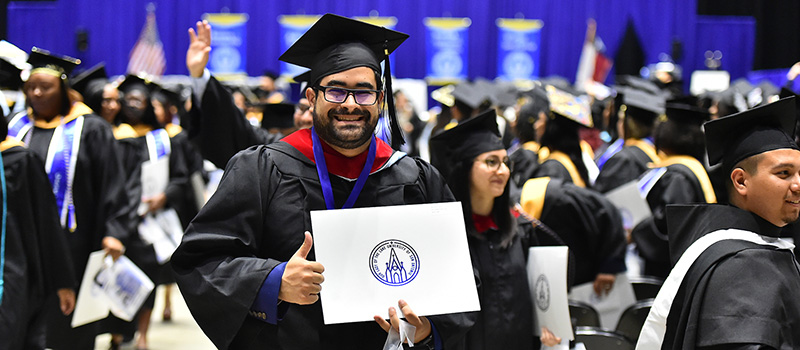 Male graduate smiling holding diploma