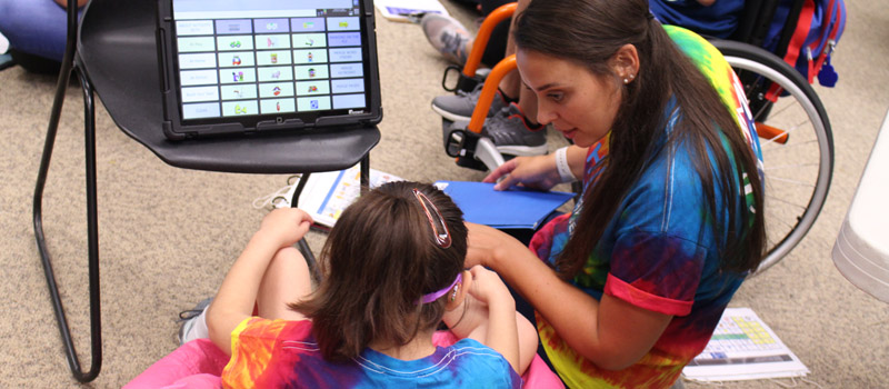 Female child using aac device during Jersig Center summer camp