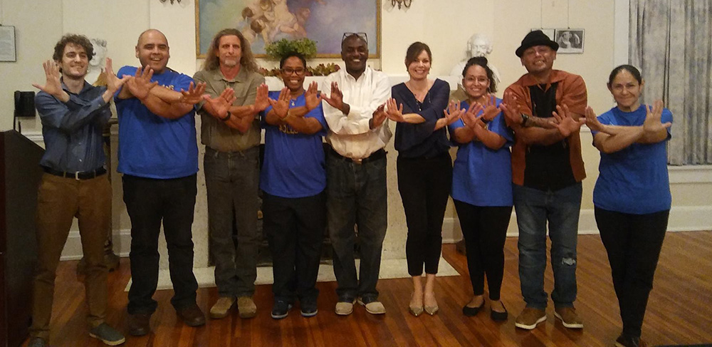 Students gathered together holding up wings up hand symbol