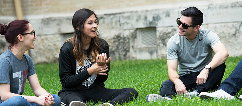 Students sitting on grass talking to each other