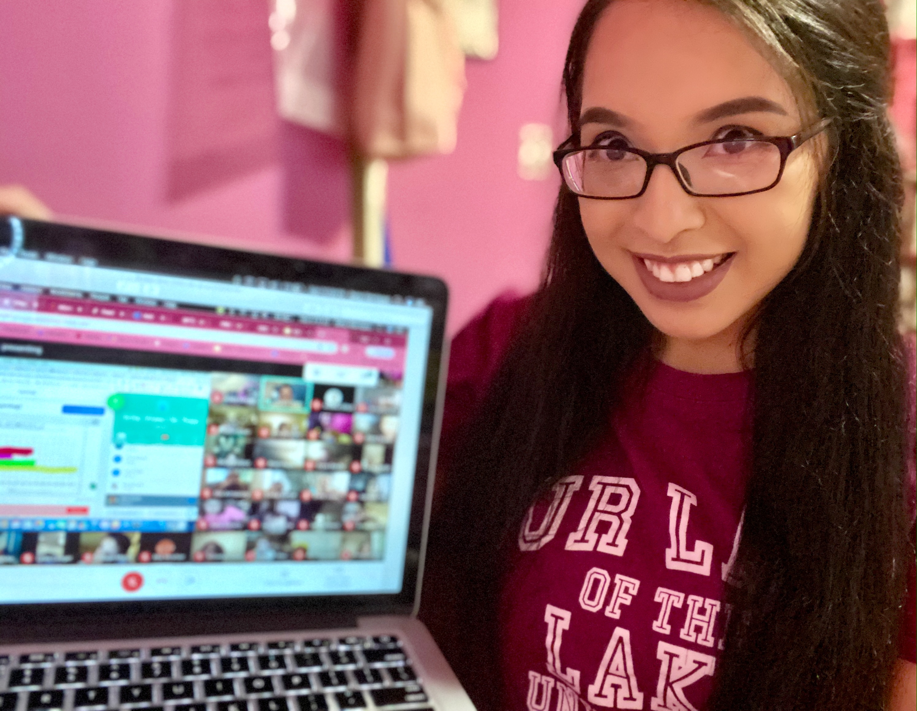 OLLU student teacher poses with laptop used to communicate with students