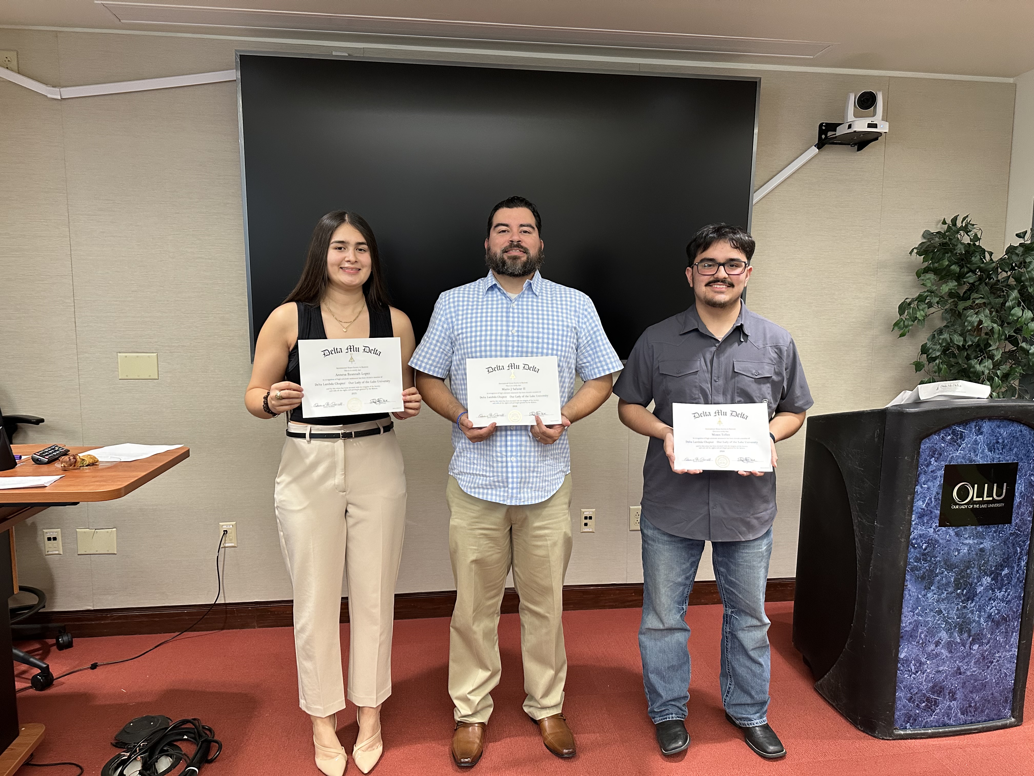 students holding honors certificate for delta mu delta