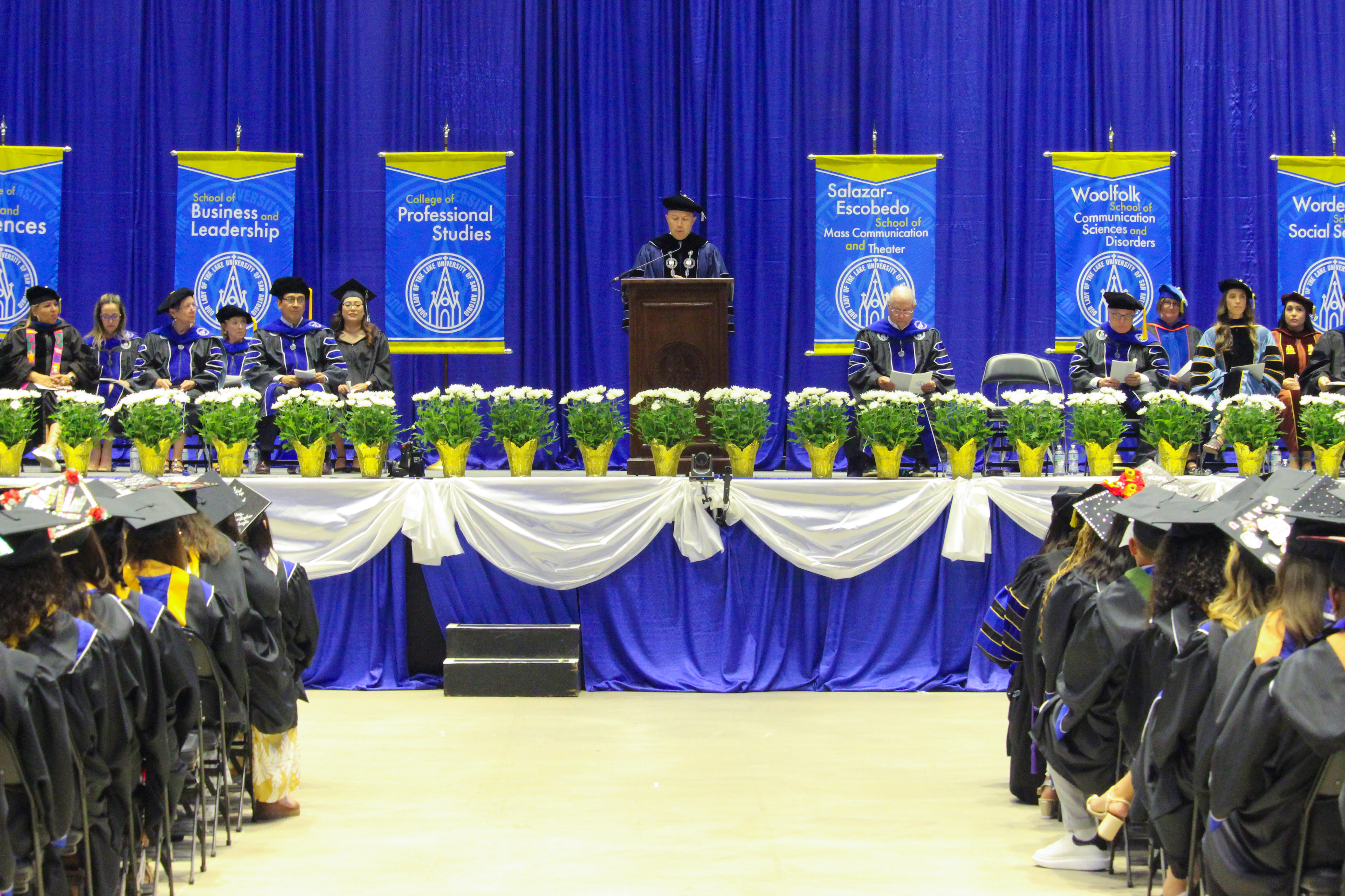 stage view of faculty in regalia during commencement ceremony