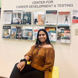 Female student smiles for photo in career services office lobby