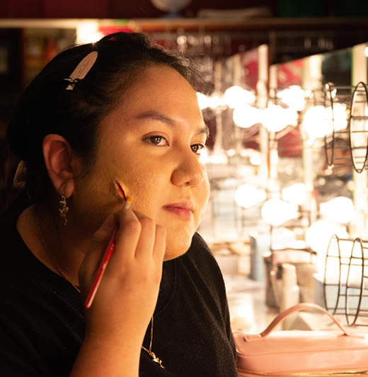 Student putting on stage makeup