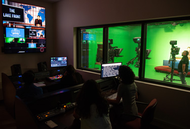 Students producing news broadcast from control room