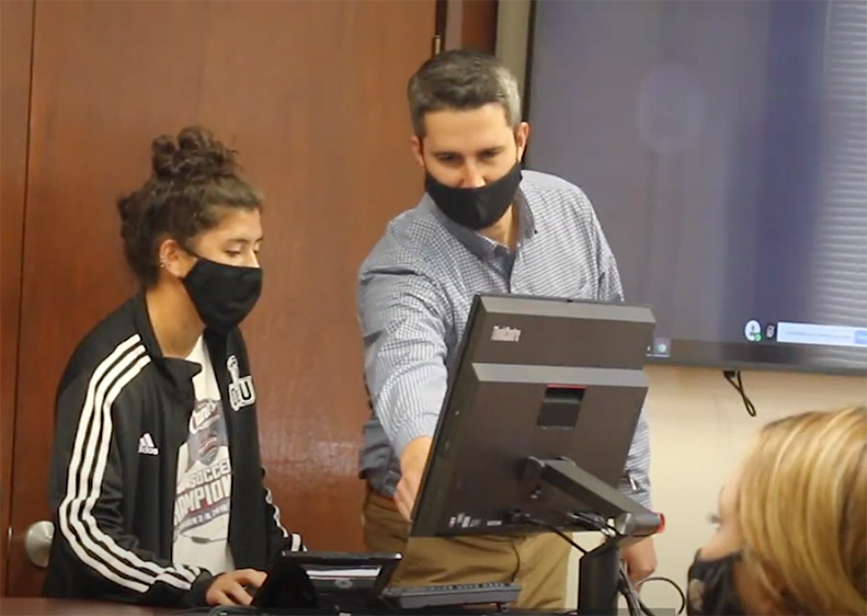 Professor helping student in class