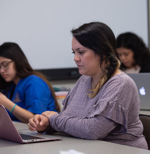 Female student working on computer in classroom