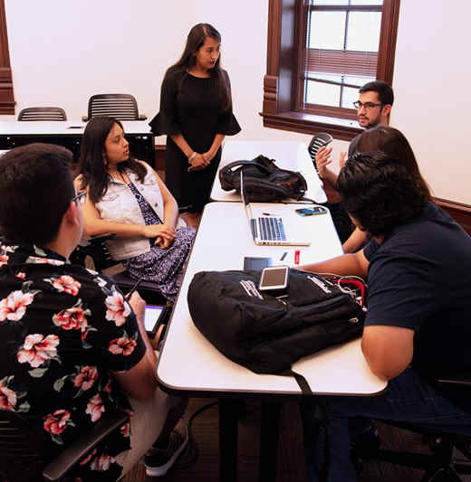 Students talking to professor in class