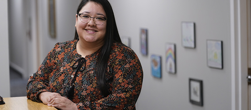 Female student poses at desk