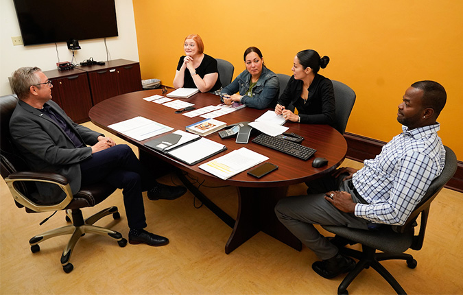 Professor and students talking at conference table