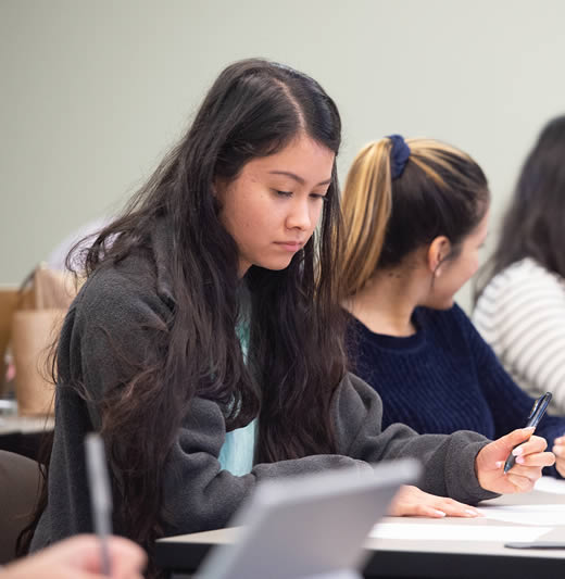 Student sitting in class writing