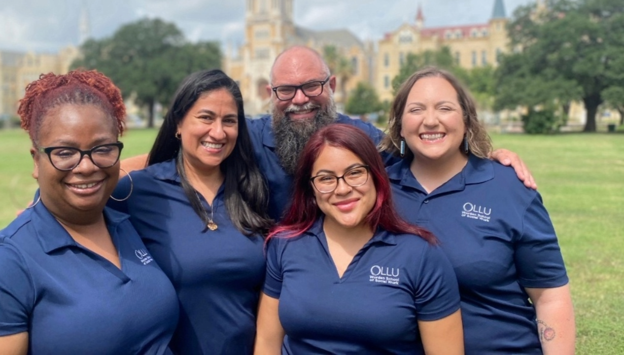 Social worker students standing in front of lawn and main building